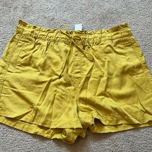 Mustard yellow Loft shorts, elastic band waist with tie. Pockets. 3” inseam